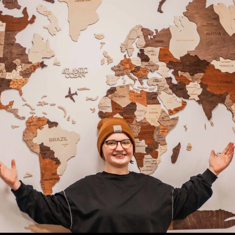 Person placing wooden map pieces on wall